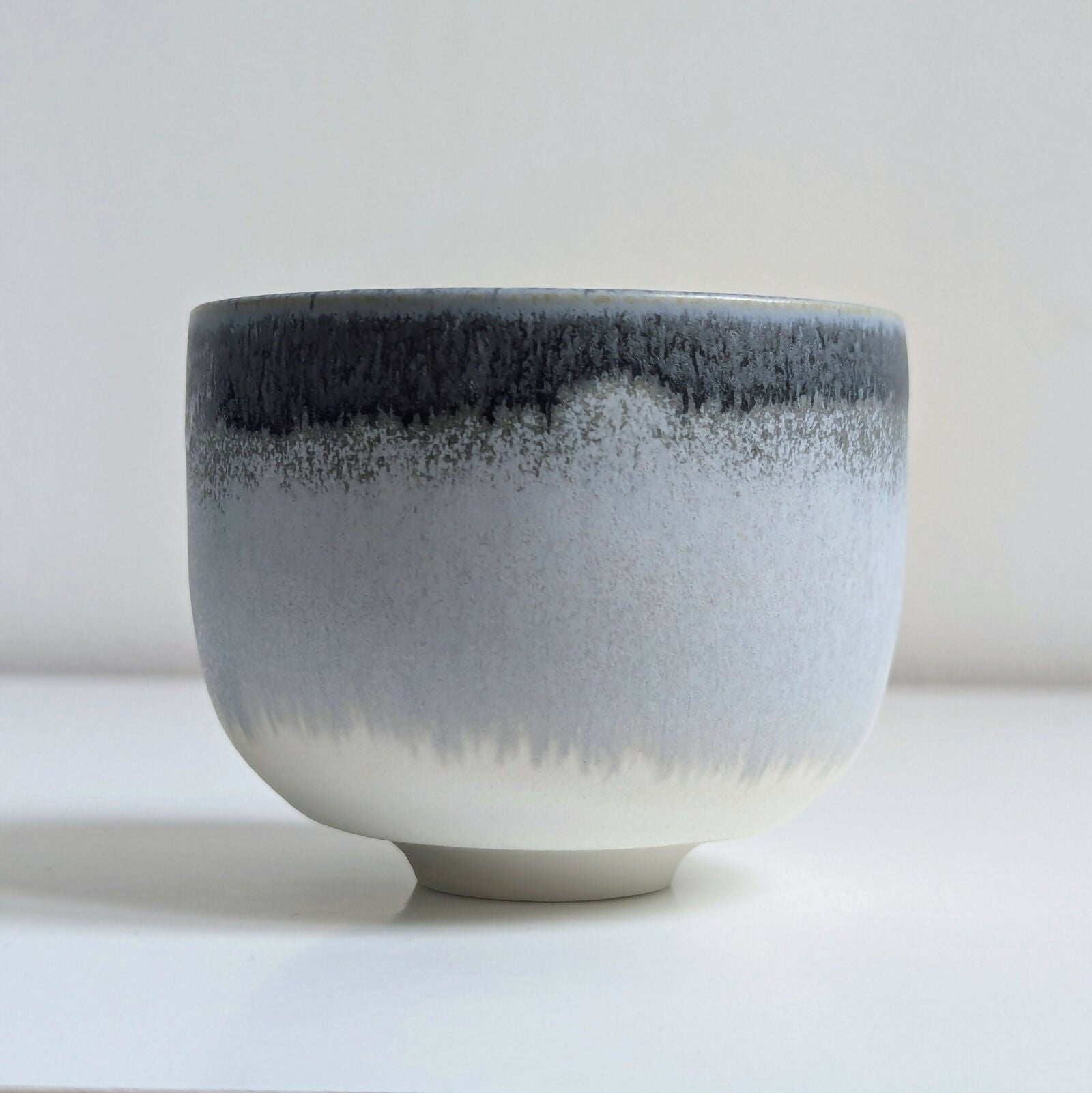 Tasse artisanale en porcelaine, dégradé d'émaux gris et blanc mats/satinés.