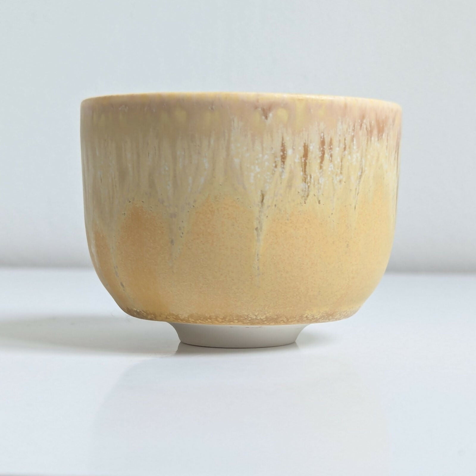 Tasse artisanale en porcelaine, émail jaune mat nuancé par une superposition d'un émail brillant à base de cendres de bois.