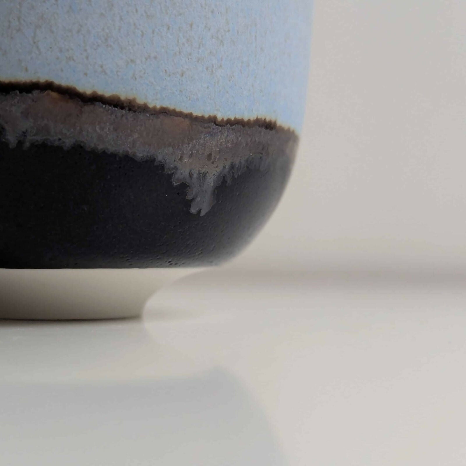 Tasse en porcelaine, émail bleu mat/satiné à l’intérieur et à l'extérieur sur la partie supérieure, émail noir brillant sur la partie inférieure, séparés par une ligne d'émail métallisé.