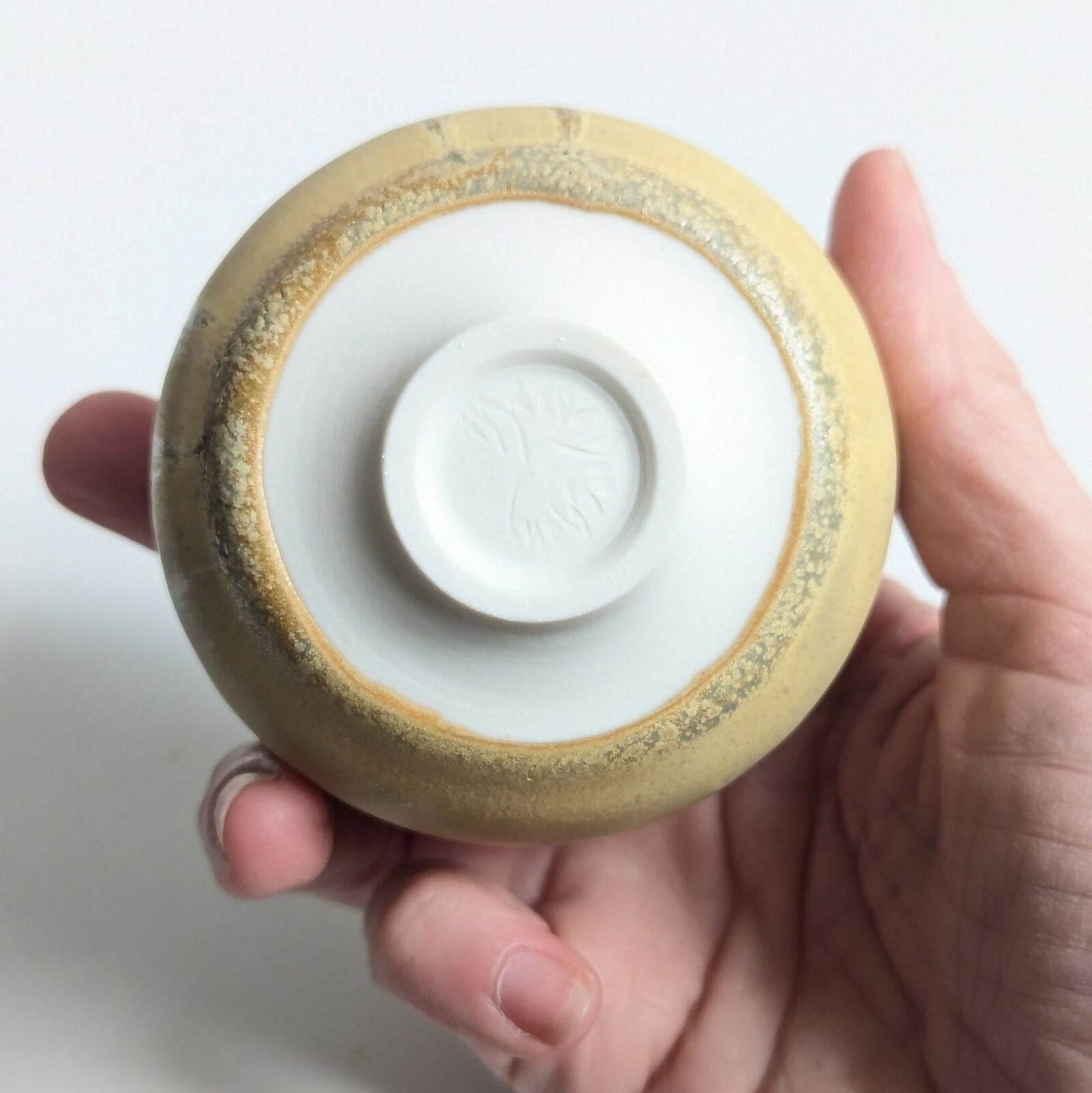 Tasse artisanale en porcelaine, émail jaune mat nuancé par une superposition d'un émail brillant à base de cendres de bois.