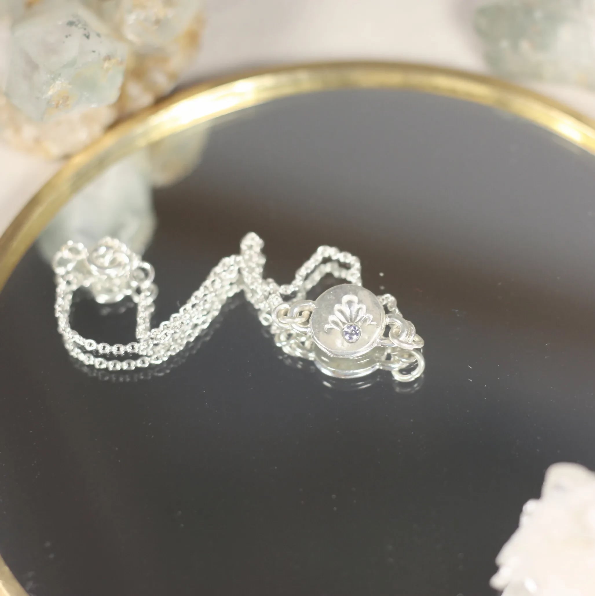 L'Écho - Un bracelet en argent avec une médaille ornée d'une pierre fine