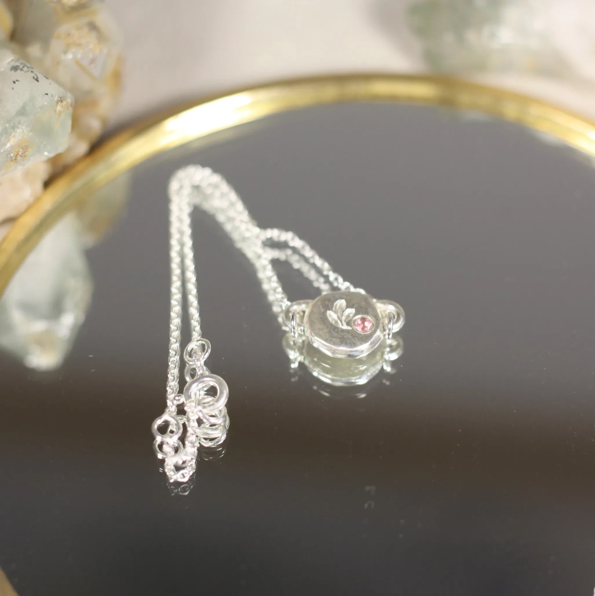 L'Écho - Un bracelet en argent avec une médaille ornée d'une pierre fine