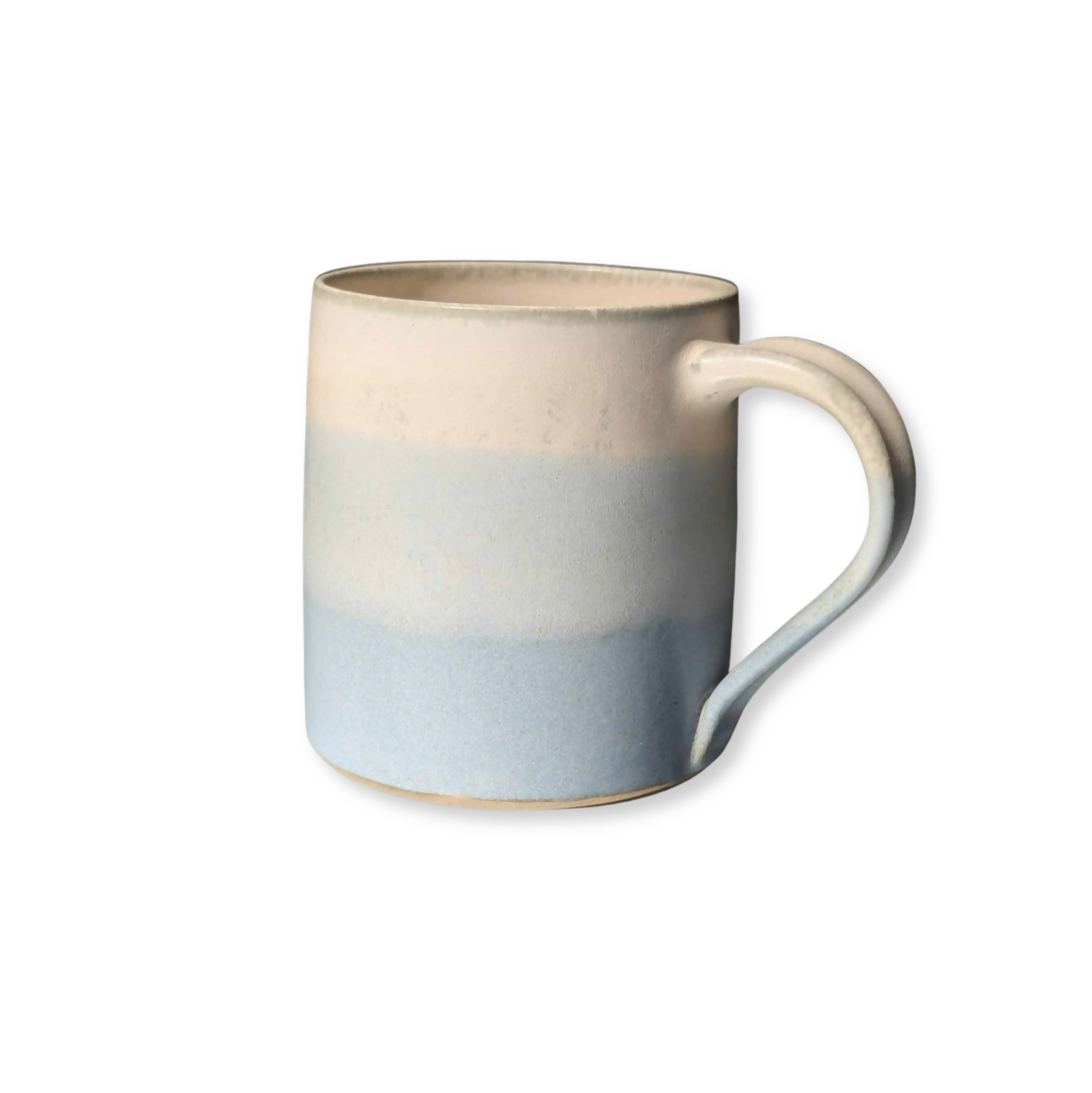 Un mug en grès blanc, tourné et ansé à la main, et émaillé en dégradé de bleu et blanc.