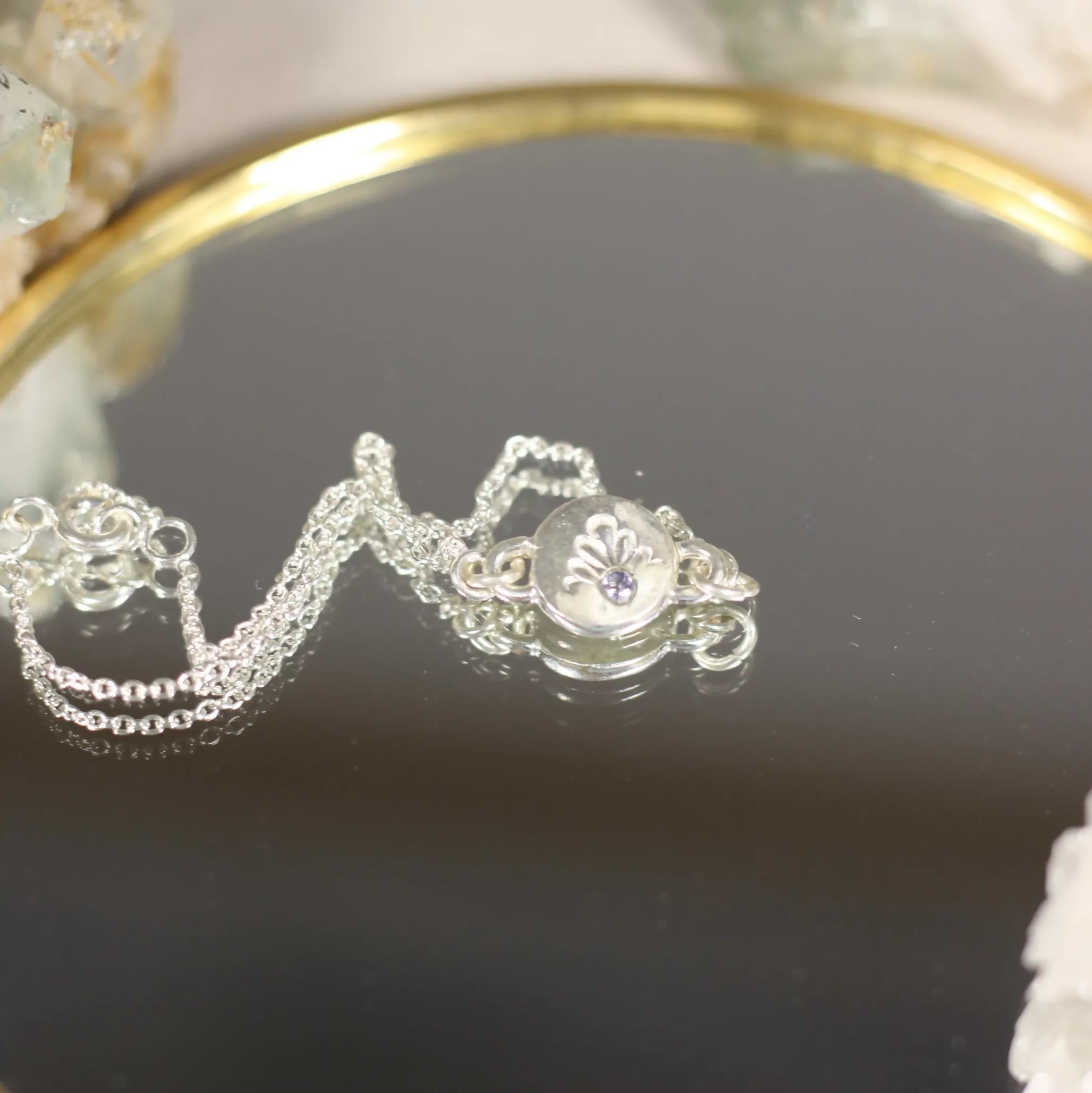 L'Écho - Un bracelet en argent avec une médaille ornée d'une pierre fine