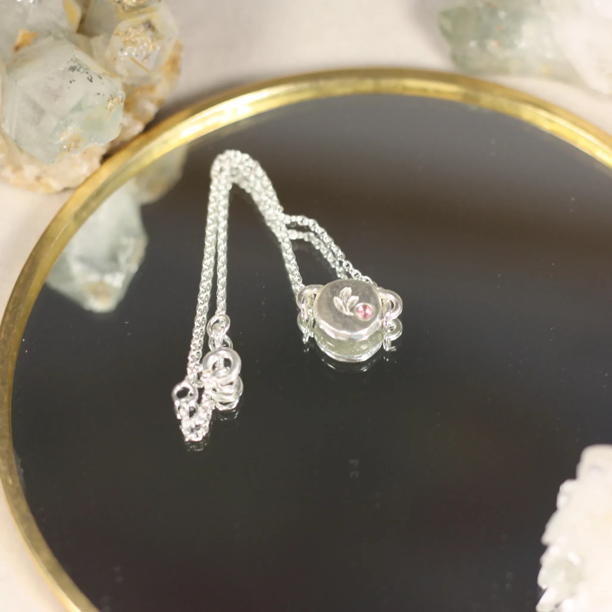 L'Écho - Un bracelet en argent avec une médaille ornée d'une pierre fine
