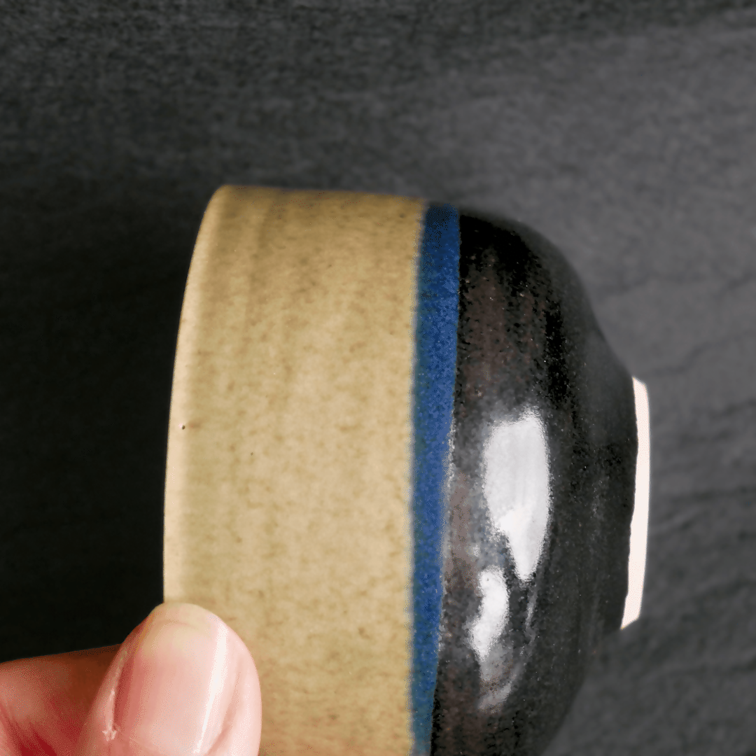 petite tasse en grès blanc, tournée à la main, et émaillé en vert céladon et noir brillant.