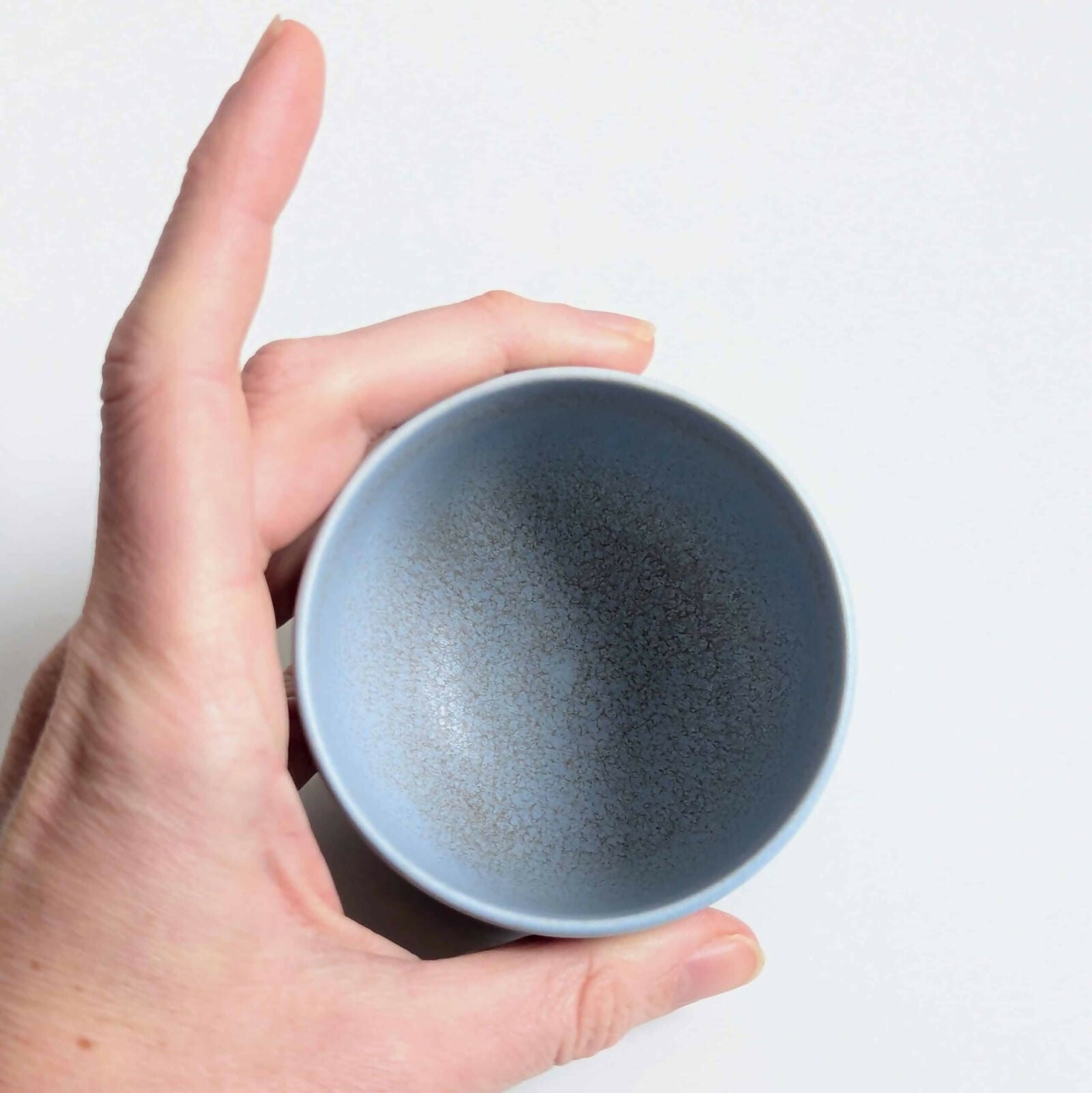 Tasse en porcelaine, émail bleu mat/satiné à l’intérieur et à l'extérieur sur la partie supérieure, émail noir brillant sur la partie inférieure, séparés par une ligne d'émail métallisé.