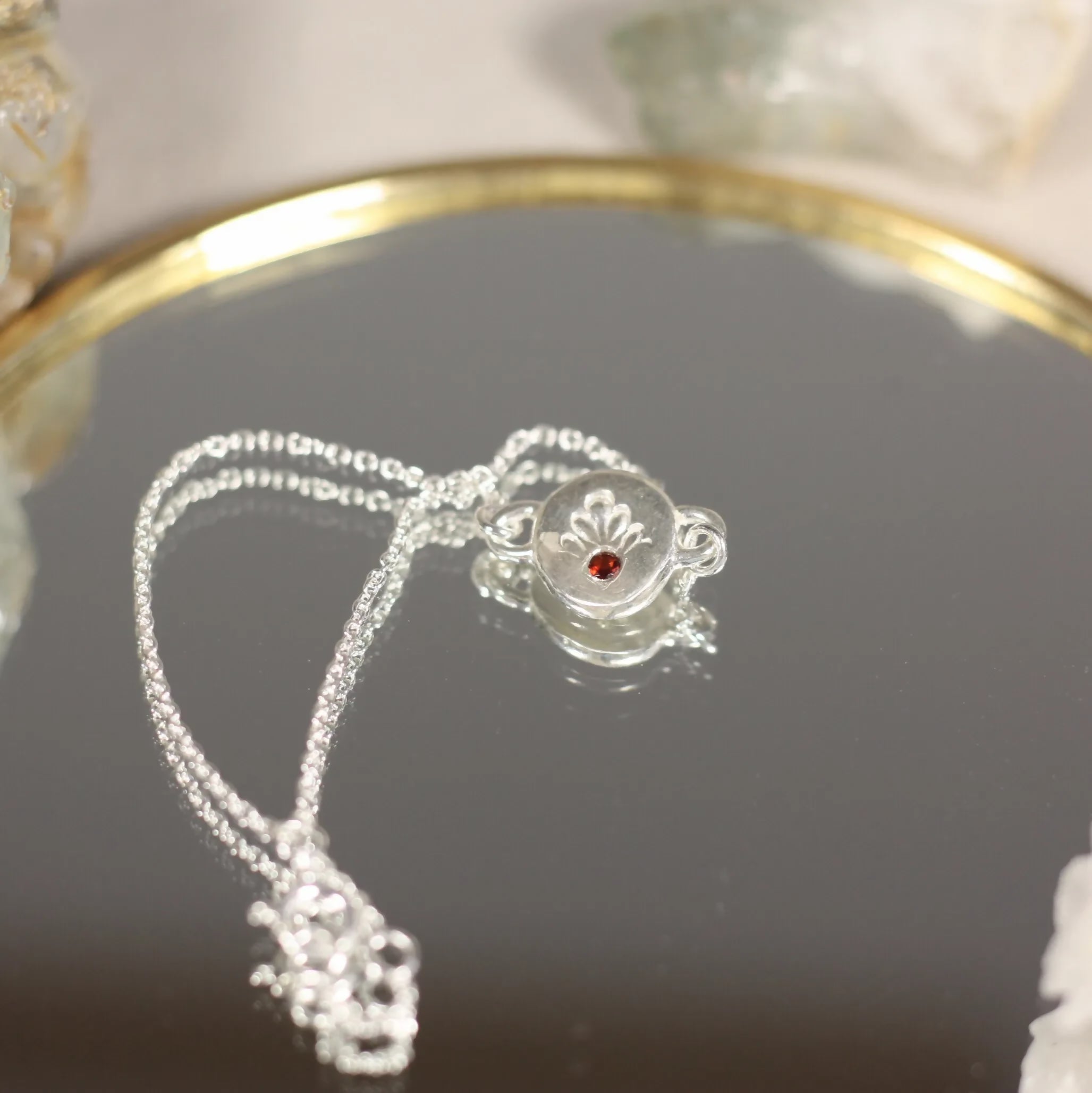 L'Écho - Un bracelet en argent avec une médaille ornée d'une pierre fine