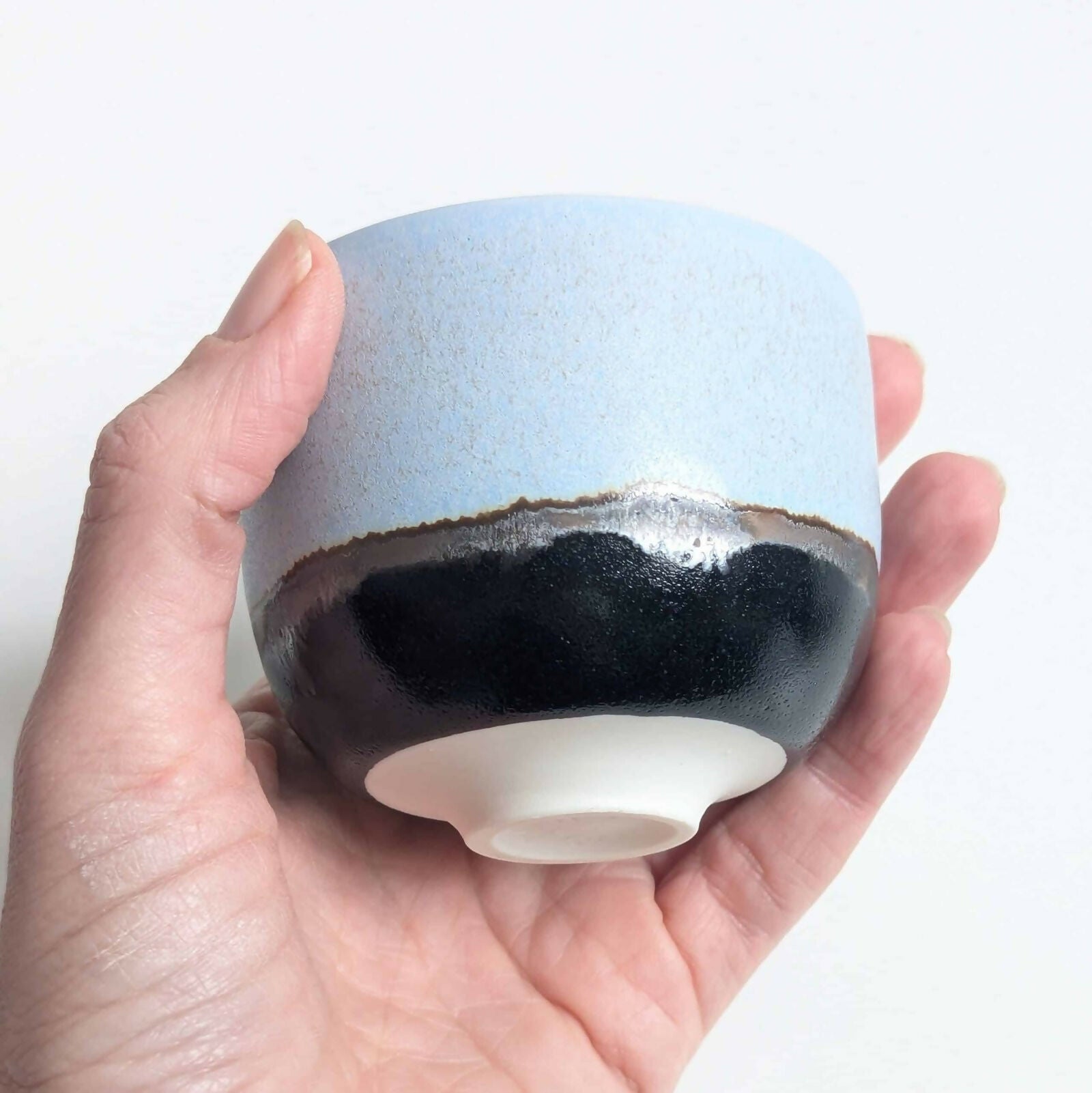 Tasse en porcelaine, émail bleu mat/satiné à l’intérieur et à l'extérieur sur la partie supérieure, émail noir brillant sur la partie inférieure, séparés par une ligne d'émail métallisé.