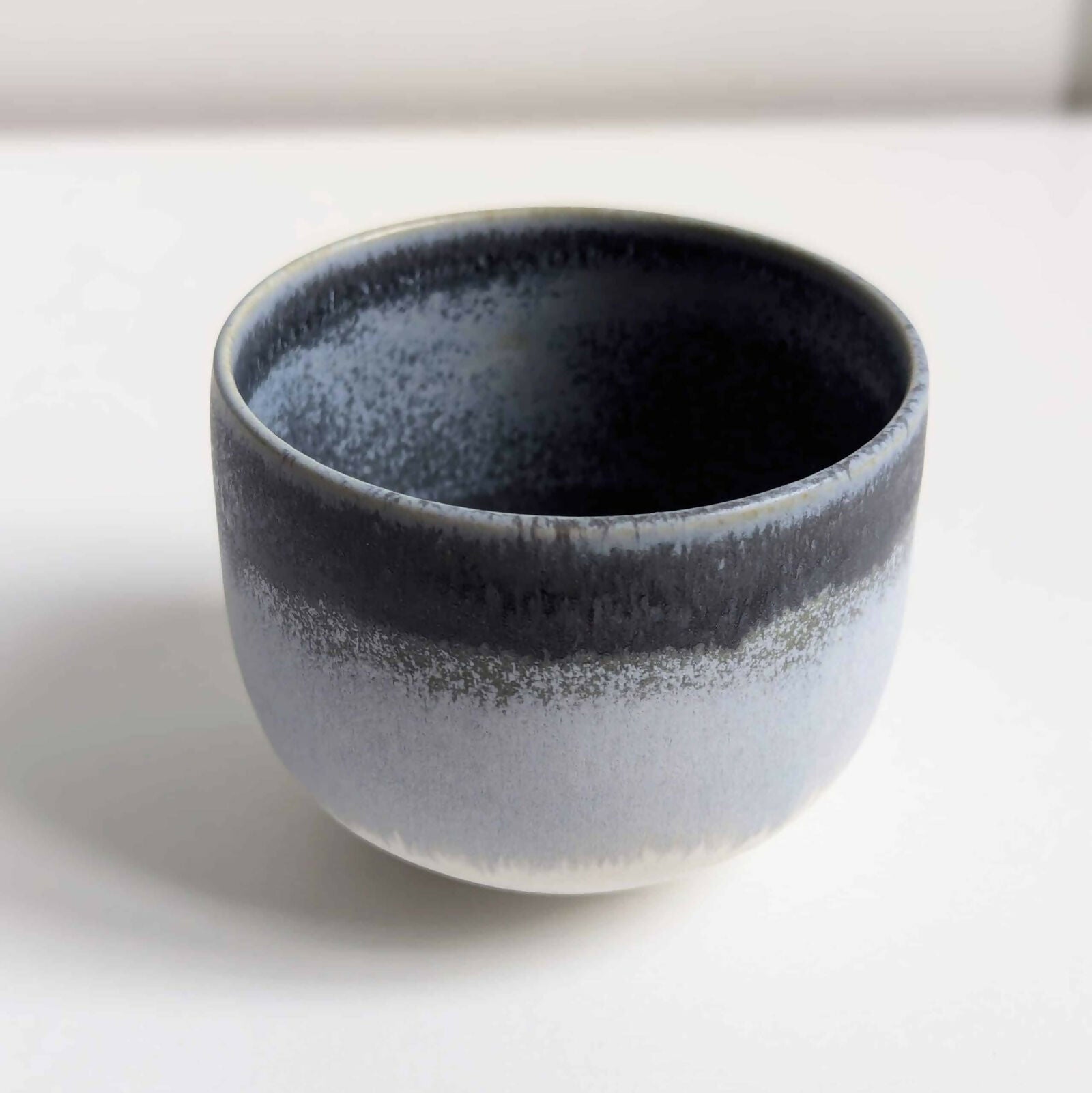 Tasse artisanale en porcelaine, dégradé d'émaux gris et blanc mats/satinés.