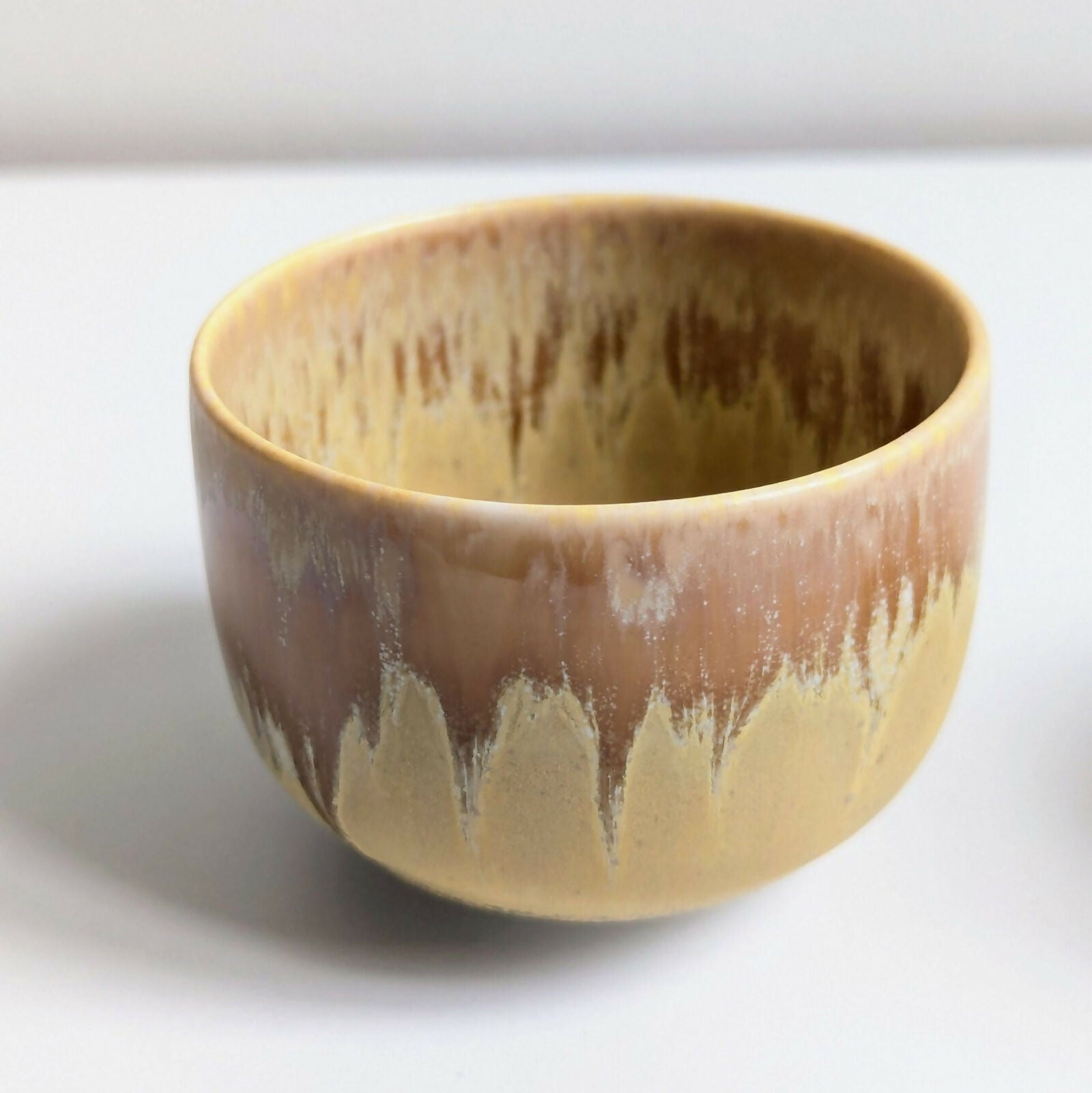 Tasse artisanale en porcelaine, émail jaune mat nuancé par une superposition d'un émail brillant à base de cendres de bois.