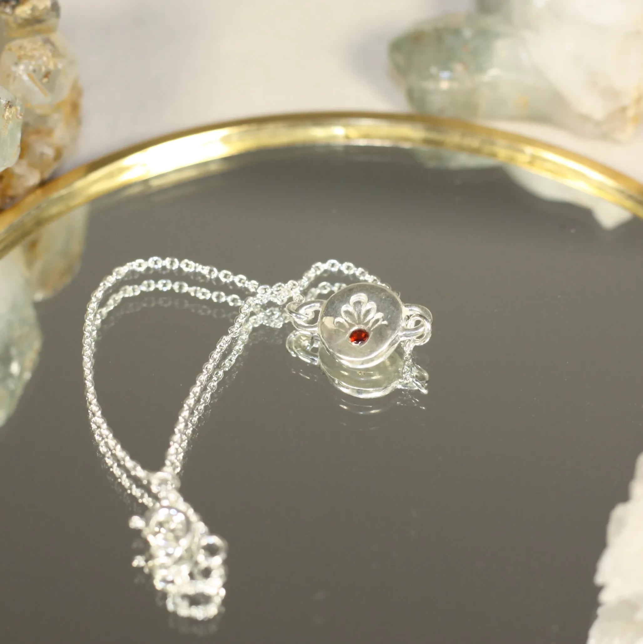L'Écho - Un bracelet en argent avec une médaille ornée d'une pierre fine